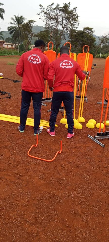 Deux membres du staff, de dos, en veste « B.S.A STAFF »